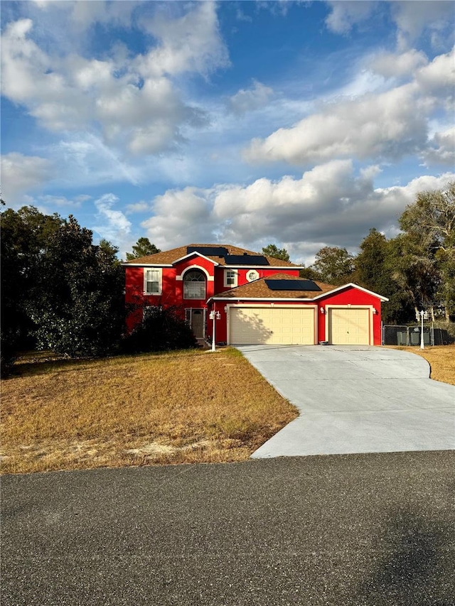 view of front facade featuring solar panels and a garage