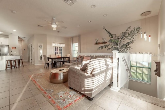 living room with ceiling fan, sink, and light tile patterned floors