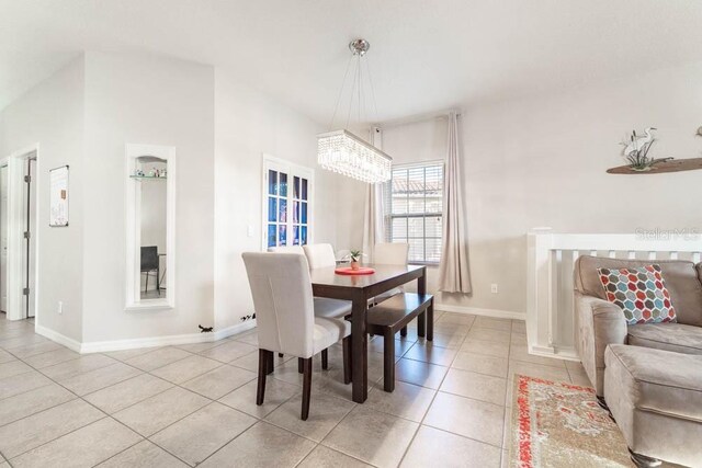 dining space with light tile patterned floors and a chandelier