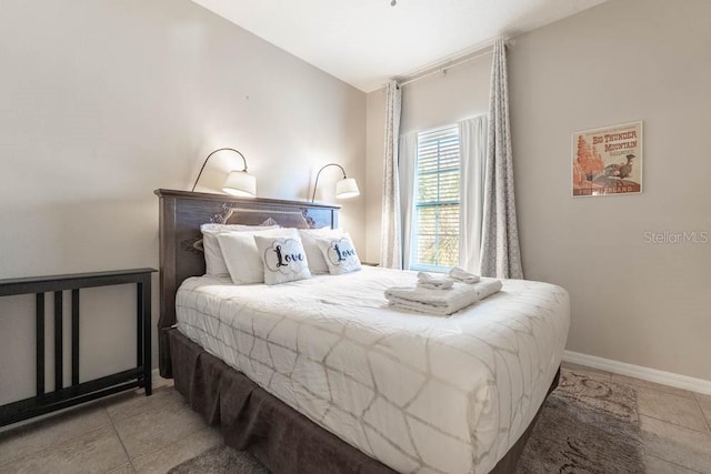 bedroom featuring lofted ceiling and light tile patterned flooring