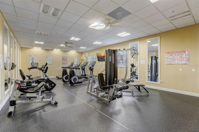 exercise room with a paneled ceiling and ceiling fan