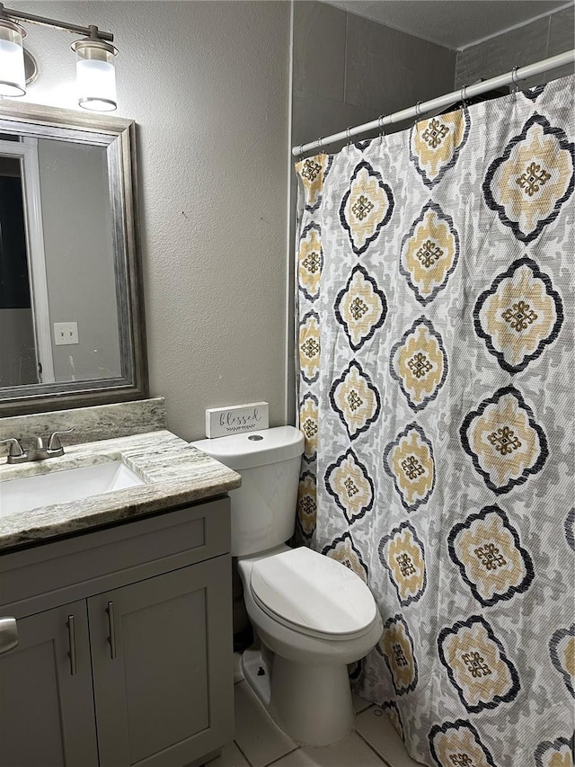 bathroom with tile patterned flooring, vanity, and toilet