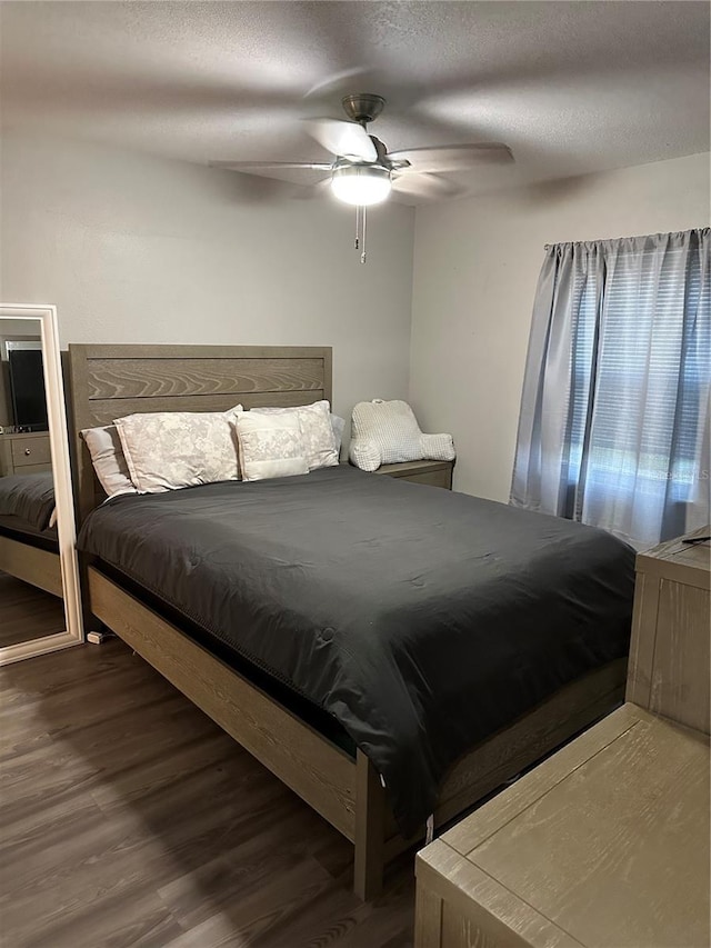 bedroom with ceiling fan, dark hardwood / wood-style flooring, and a textured ceiling