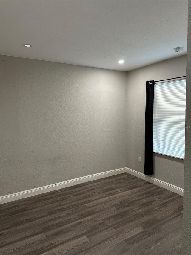 empty room with dark hardwood / wood-style flooring