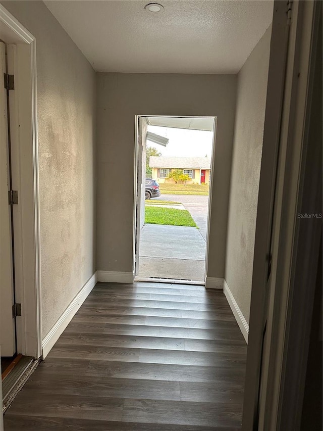 entryway with dark hardwood / wood-style floors and a textured ceiling