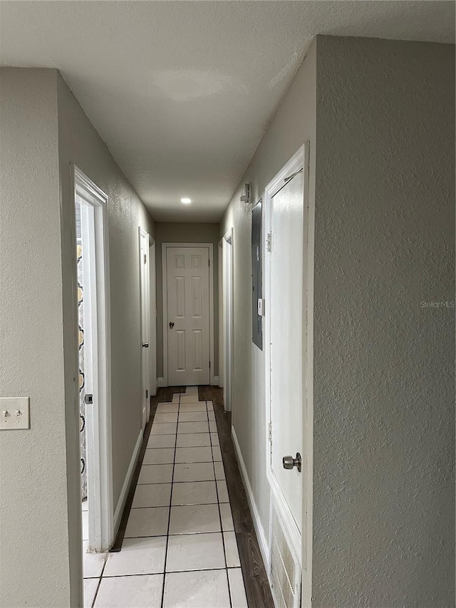 hall with light tile patterned floors and a textured ceiling