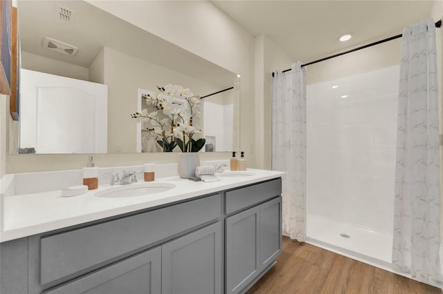 bathroom with curtained shower, vanity, and wood-type flooring