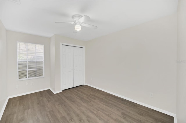 unfurnished bedroom with ceiling fan, dark hardwood / wood-style floors, and a closet