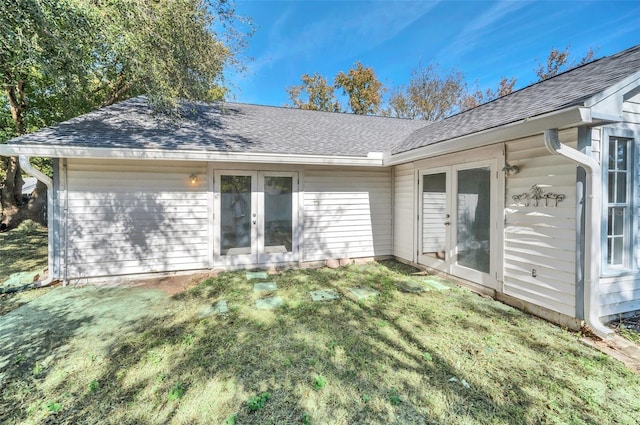 back of house featuring french doors and a lawn