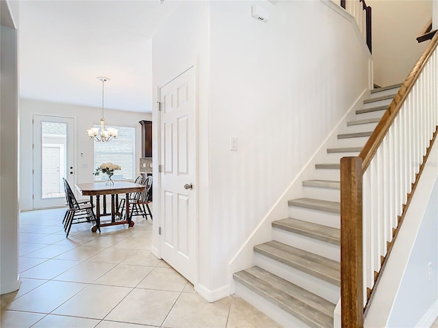 stairs with tile patterned flooring and a chandelier