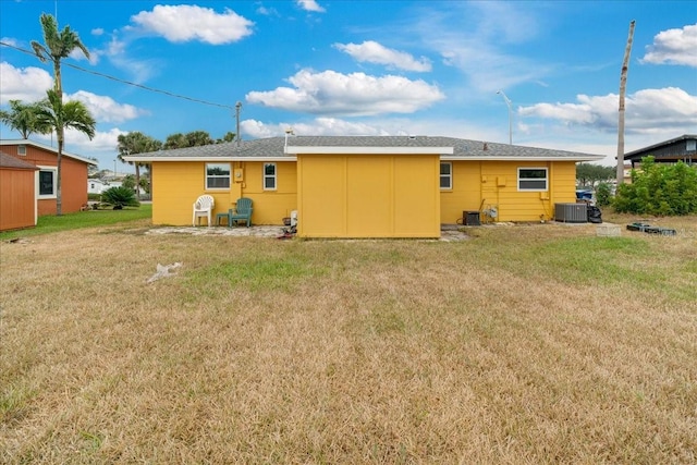 rear view of house with a yard and central AC unit