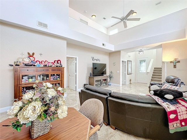 living room with light tile patterned floors, a towering ceiling, and ceiling fan