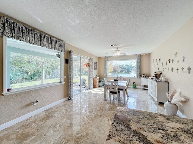 dining space with a textured ceiling and ceiling fan