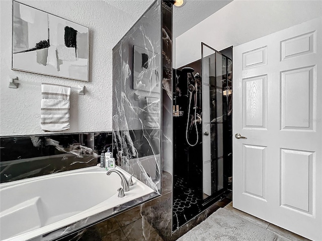 bathroom featuring a textured ceiling and separate shower and tub