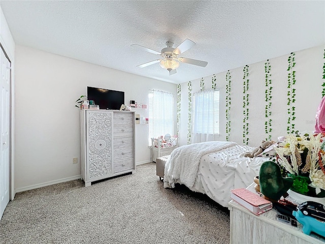 carpeted bedroom with ceiling fan, a closet, and a textured ceiling