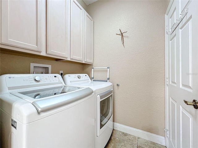 washroom with cabinets, light tile patterned floors, and washer and clothes dryer