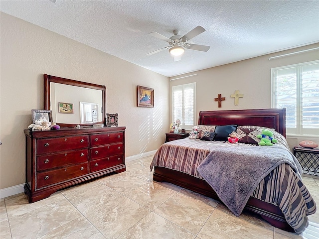 bedroom featuring multiple windows, a textured ceiling, and ceiling fan