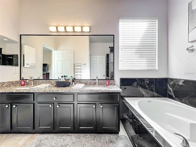 bathroom with vanity and tiled bath