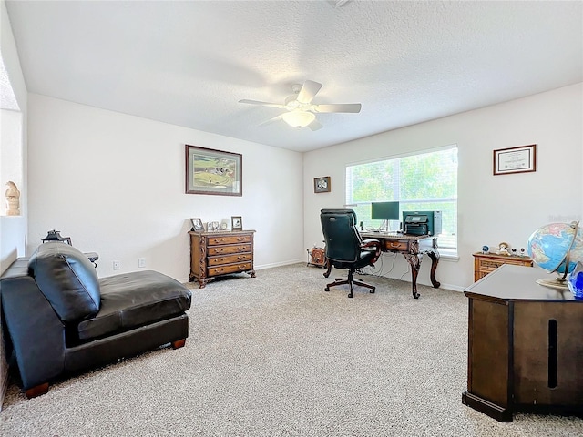 carpeted office space featuring a textured ceiling and ceiling fan