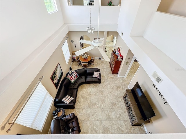 living room featuring a towering ceiling and ceiling fan