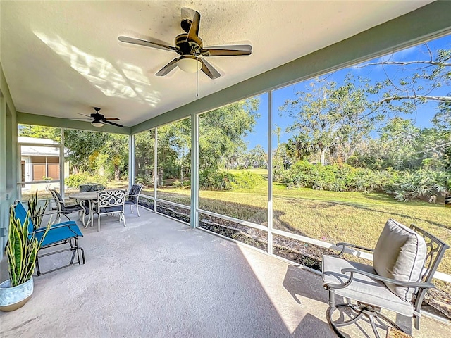 unfurnished sunroom with ceiling fan