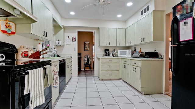 kitchen with ceiling fan, ventilation hood, cream cabinets, light tile patterned floors, and black appliances