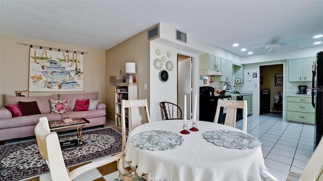 dining room with ceiling fan, light tile patterned floors, and a textured ceiling