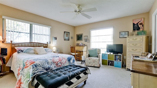 carpeted bedroom featuring multiple windows and ceiling fan