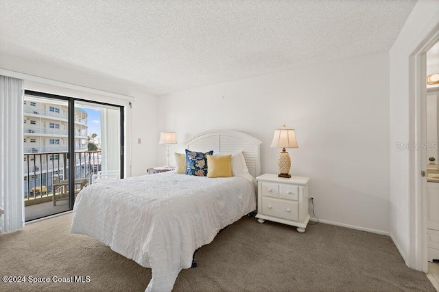 bedroom with a textured ceiling, carpet floors, and access to outside