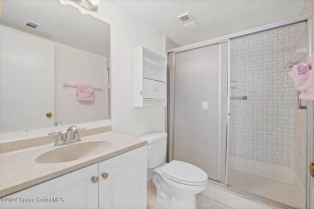 bathroom featuring tile patterned flooring, vanity, an enclosed shower, and toilet