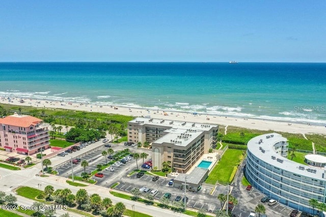 birds eye view of property featuring a water view and a beach view