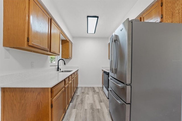 kitchen featuring stainless steel appliances, light hardwood / wood-style floors, and sink