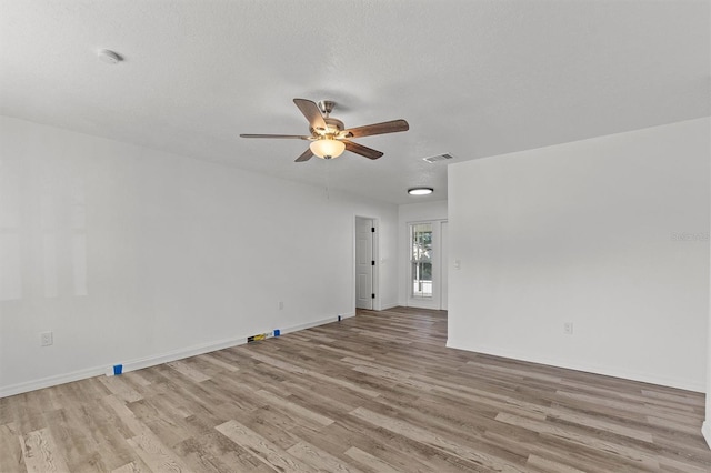 unfurnished room with ceiling fan, a textured ceiling, and light hardwood / wood-style flooring