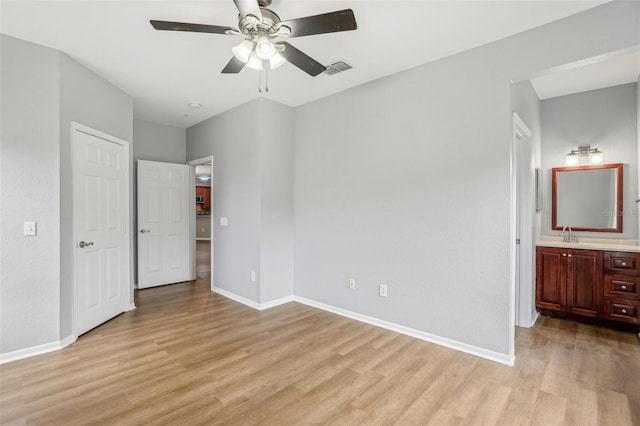 unfurnished bedroom with connected bathroom, light hardwood / wood-style floors, ceiling fan, and sink