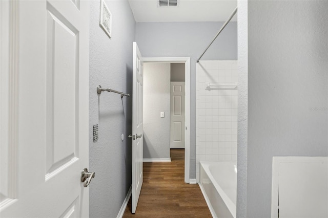 bathroom with tiled shower / bath and hardwood / wood-style flooring