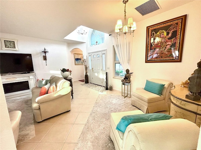 living room featuring lofted ceiling, light tile patterned floors, and a chandelier