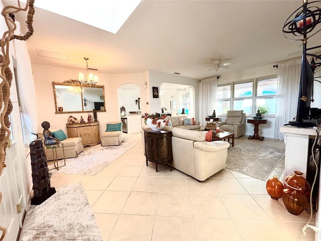 living room featuring light tile patterned floors and ceiling fan with notable chandelier