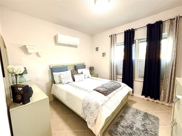 tiled bedroom with a wall mounted air conditioner and a textured ceiling