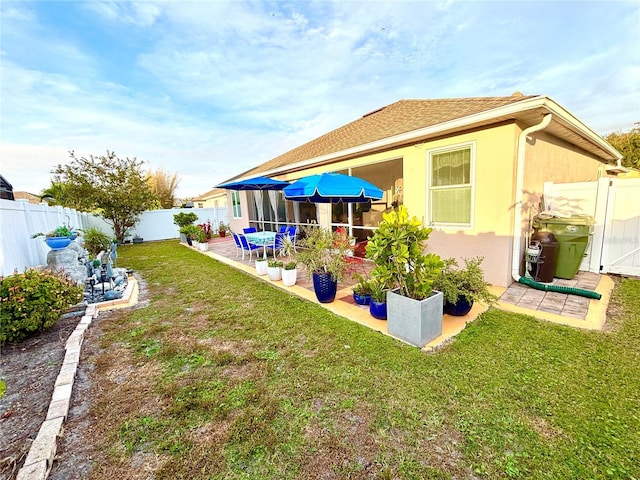 back of house featuring a yard and a patio