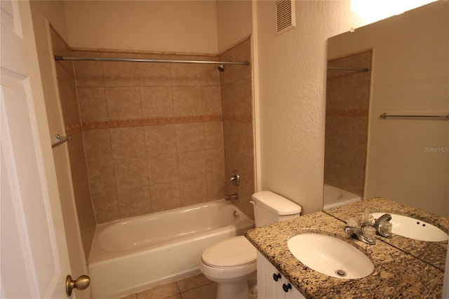 full bathroom featuring vanity, tile patterned flooring, tiled shower / bath, and toilet