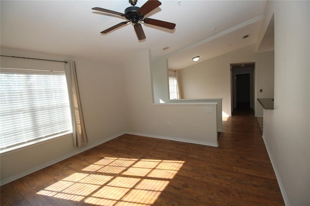 empty room featuring dark hardwood / wood-style floors, ceiling fan, and vaulted ceiling