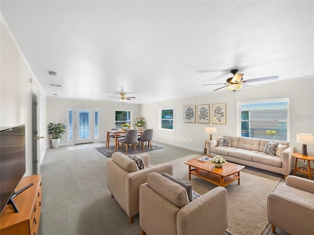 carpeted living room featuring ceiling fan and crown molding