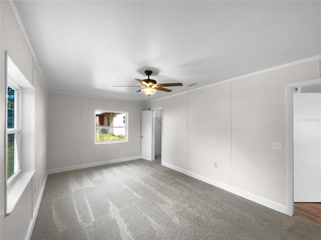 unfurnished room with carpet flooring, ceiling fan, and crown molding