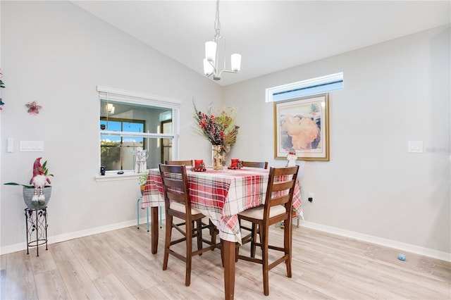 dining space with lofted ceiling, light wood-type flooring, and an inviting chandelier