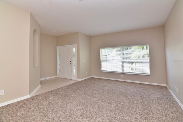 unfurnished room featuring light carpet