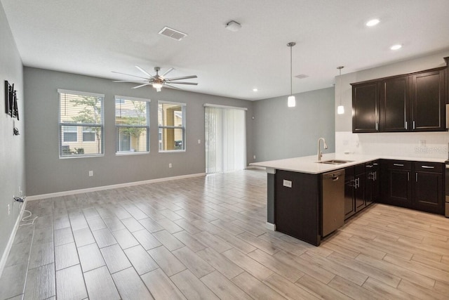 kitchen with kitchen peninsula, ceiling fan, sink, decorative light fixtures, and light hardwood / wood-style floors