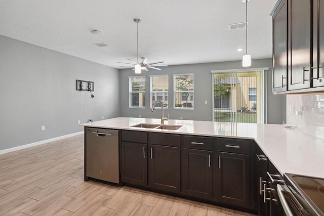 kitchen with pendant lighting, sink, appliances with stainless steel finishes, dark brown cabinets, and light hardwood / wood-style floors