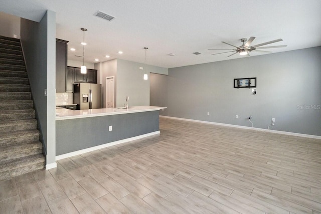 kitchen with ceiling fan, stainless steel fridge, light hardwood / wood-style floors, and decorative light fixtures