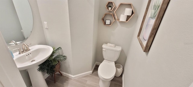 bathroom with wood-type flooring and toilet