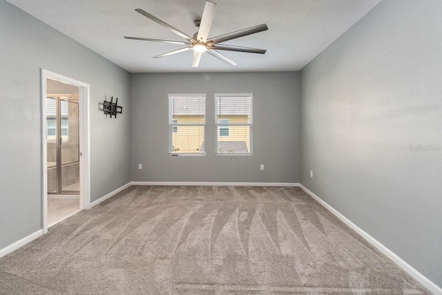 carpeted spare room with ceiling fan and a textured ceiling